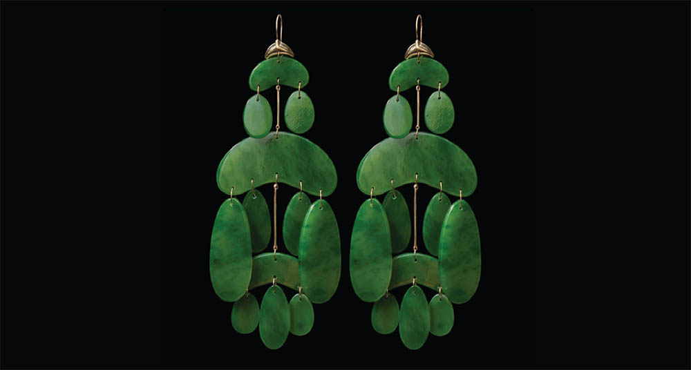 Jade green earrings on a black background.